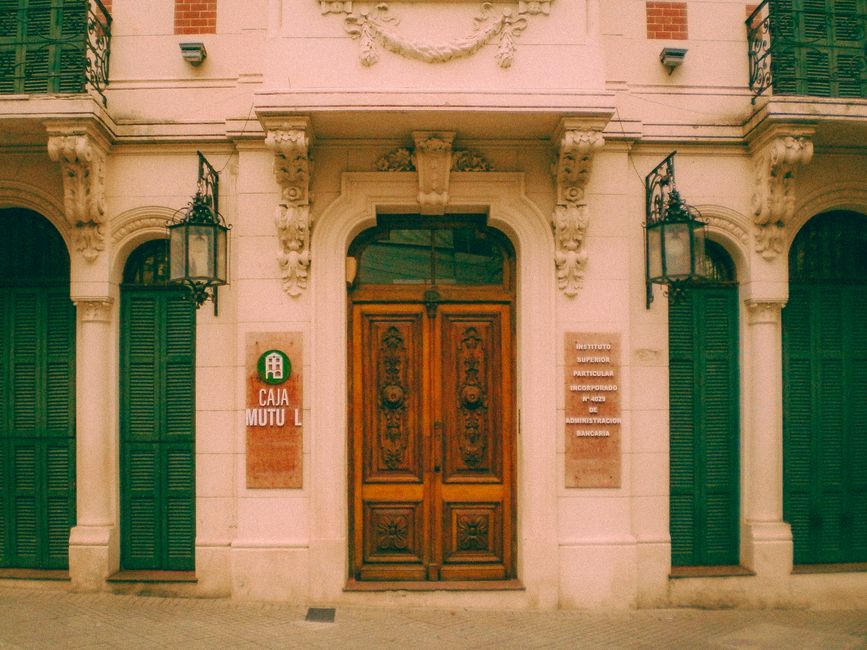 Puertas neoclásicas de madera en la entrada de un edificio histórico en Rosario.