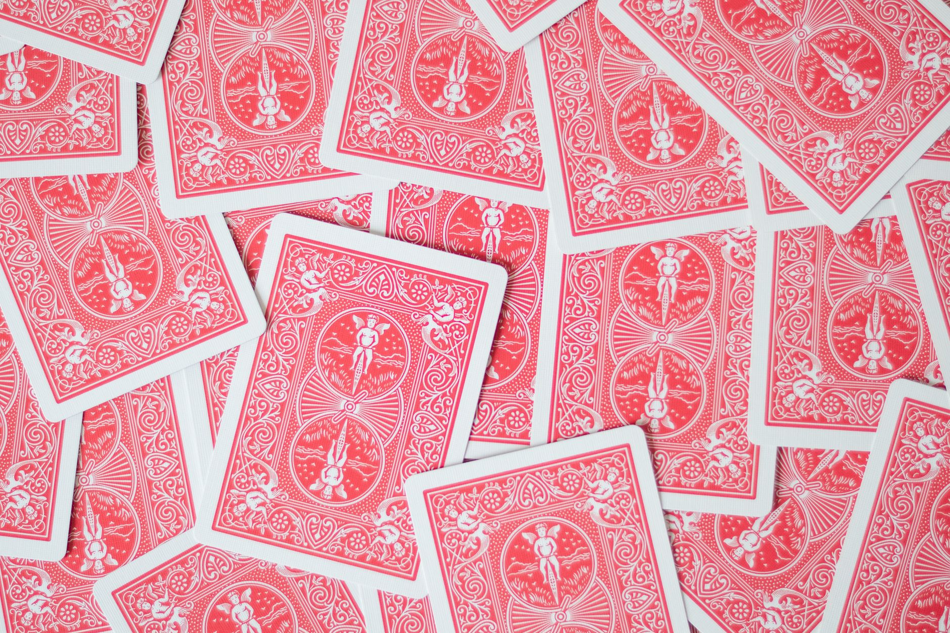 Red playing cards scattered creating an intricate and ornate pattern for gaming or decor.