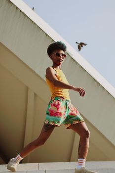 A fashionable woman posing in front of modern architecture in Berlin, Germany.