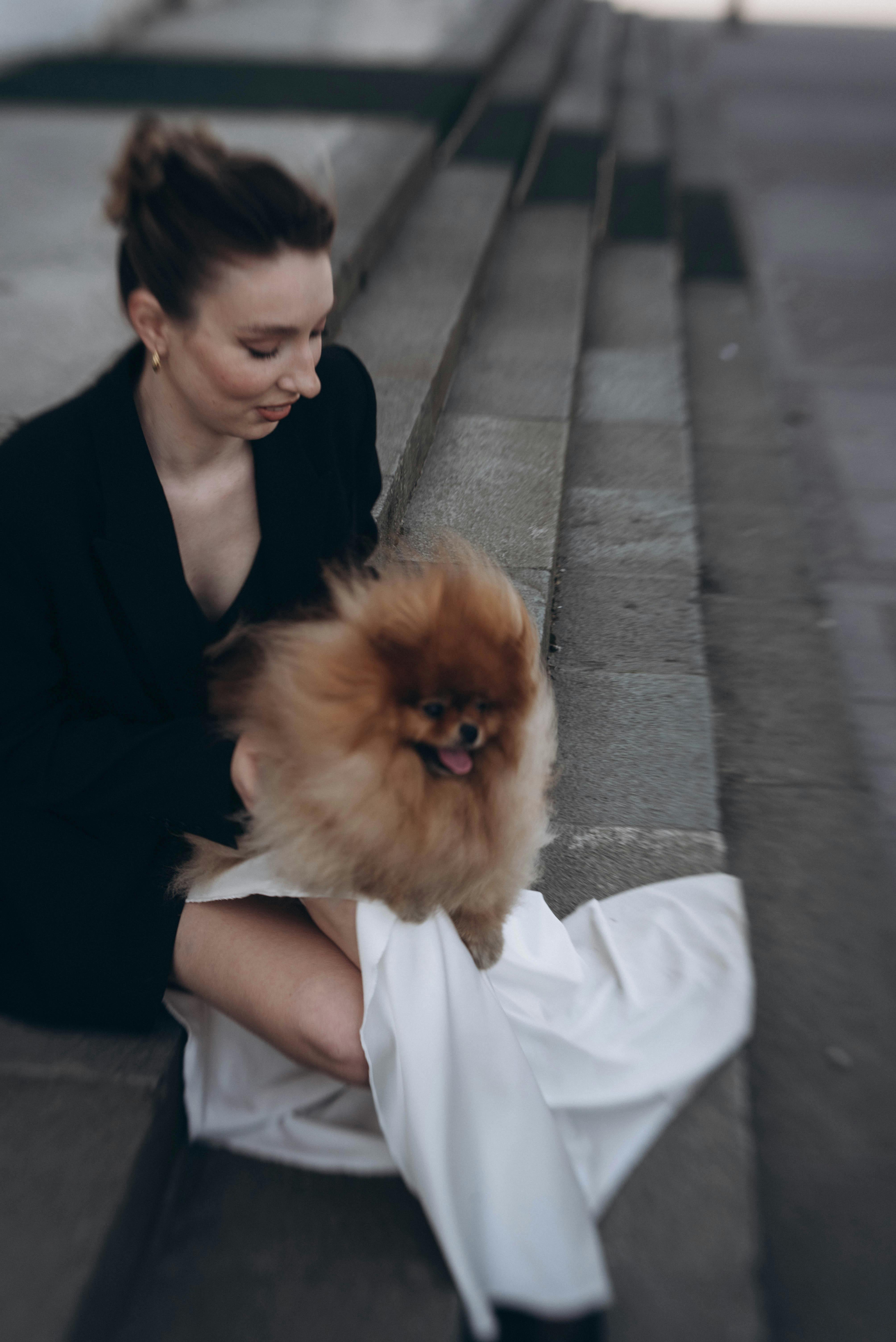 A woman sitting on some steps with a dog