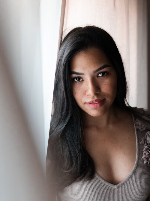 Free Stunning portrait of a young woman with long dark hair looking confidently at the camera. Stock Photo