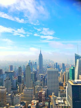 A breathtaking view of the New York City skyline featuring the iconic Empire State Building under a bright blue sky.