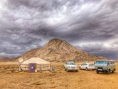 Three Vehicles Beside Mountain Under Cloudy Sky