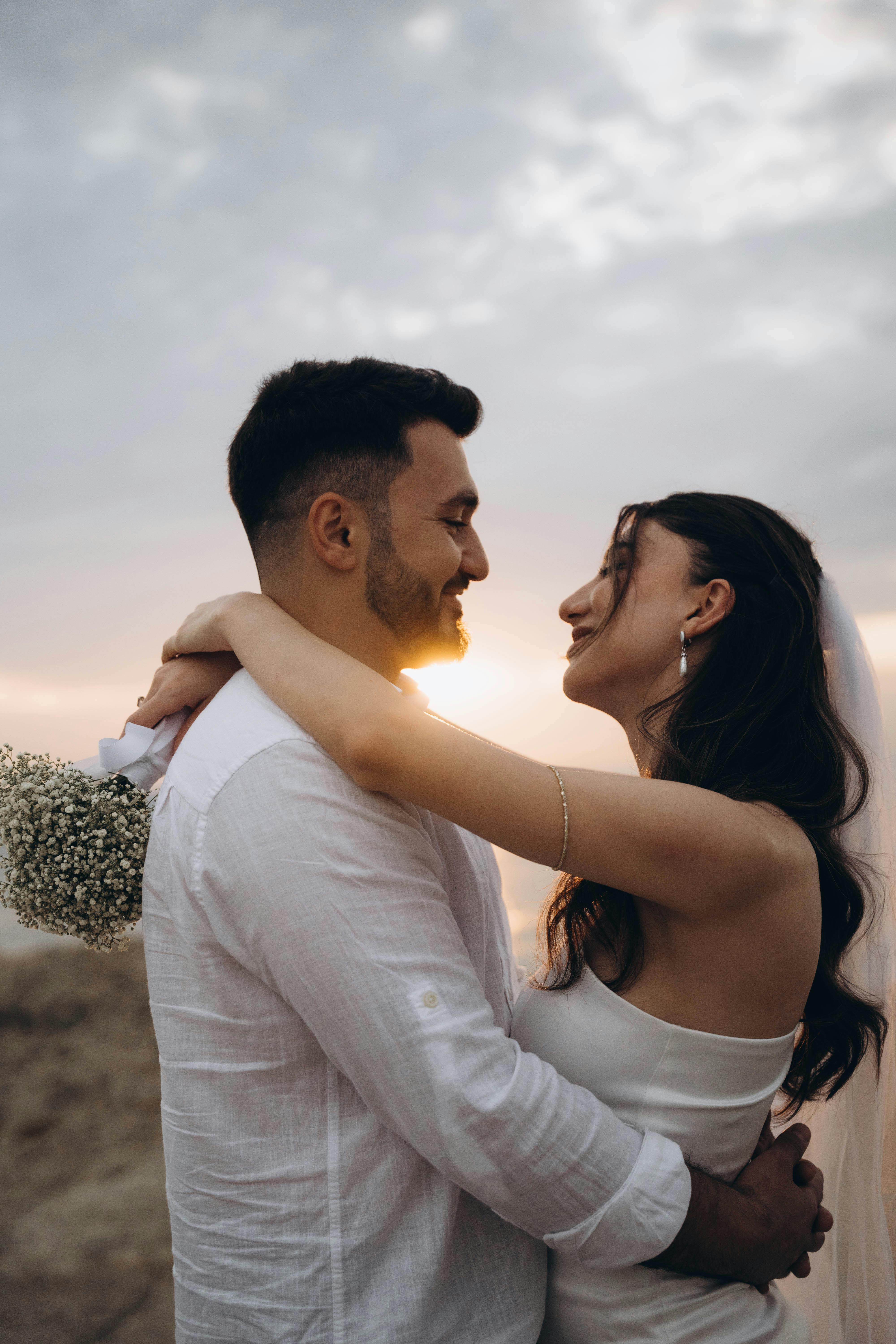 newlyweds embracing at sunset