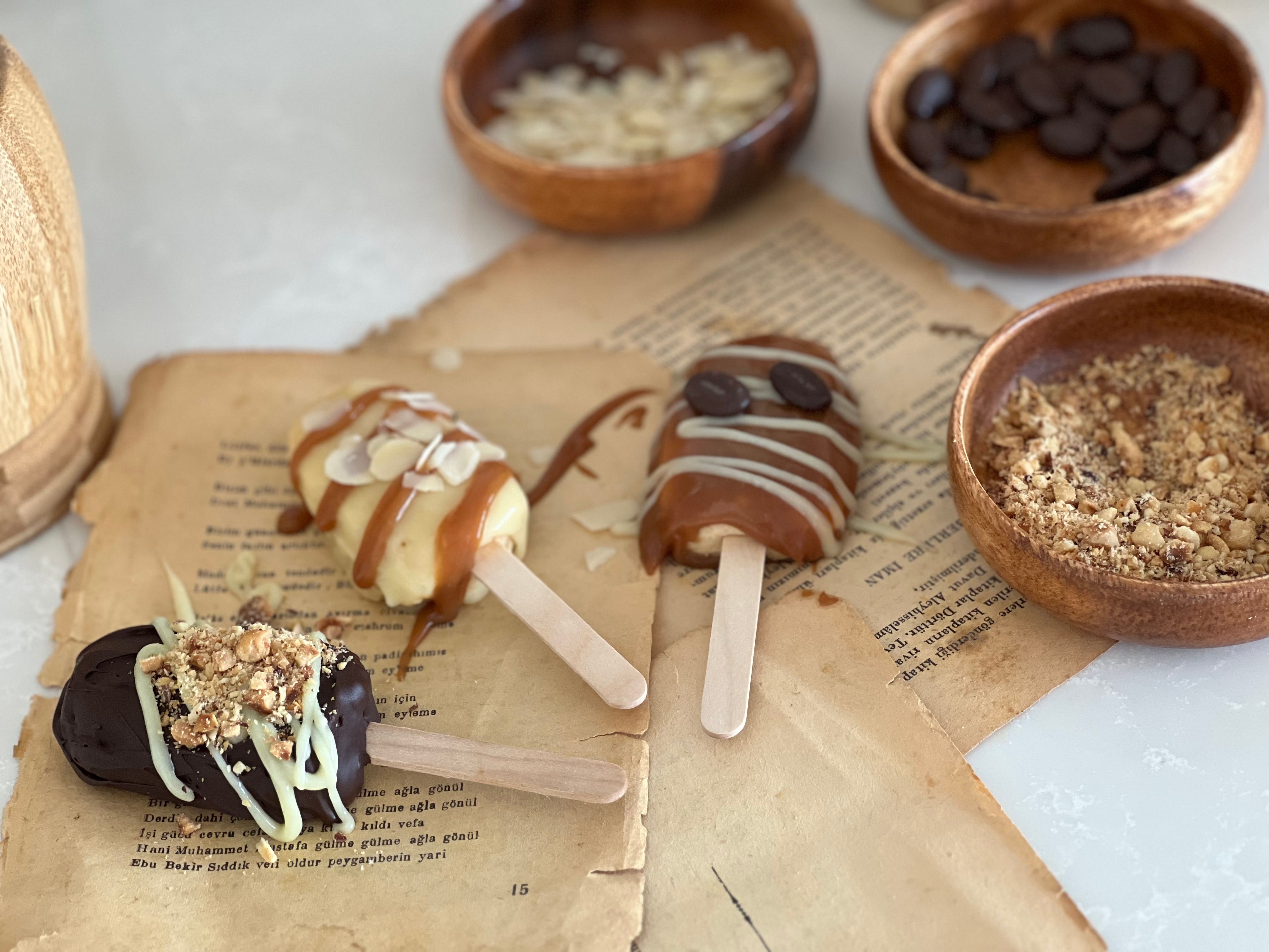 Delicious homemade ice cream popsicles with caramel and chocolate toppings, displayed on vintage paper.
