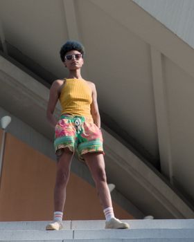 Young African American woman poses confidently in colorful summer attire. Berlin backdrop enhances the modern vibe.