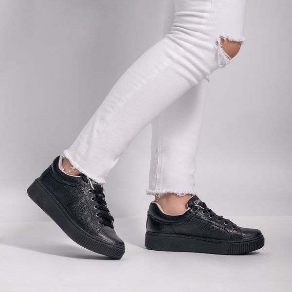 Close-up of sneakers worn with cuffed jeans, photo by Jose Martin Segura Benites on Pexels