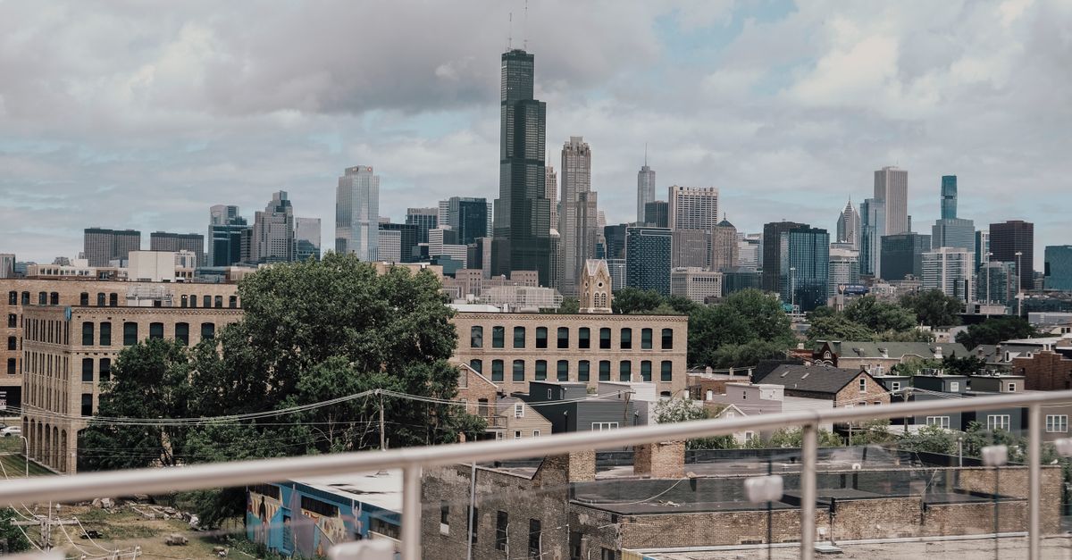 A clear view of the Chicago skyline from a rooftop with cloudy skies.