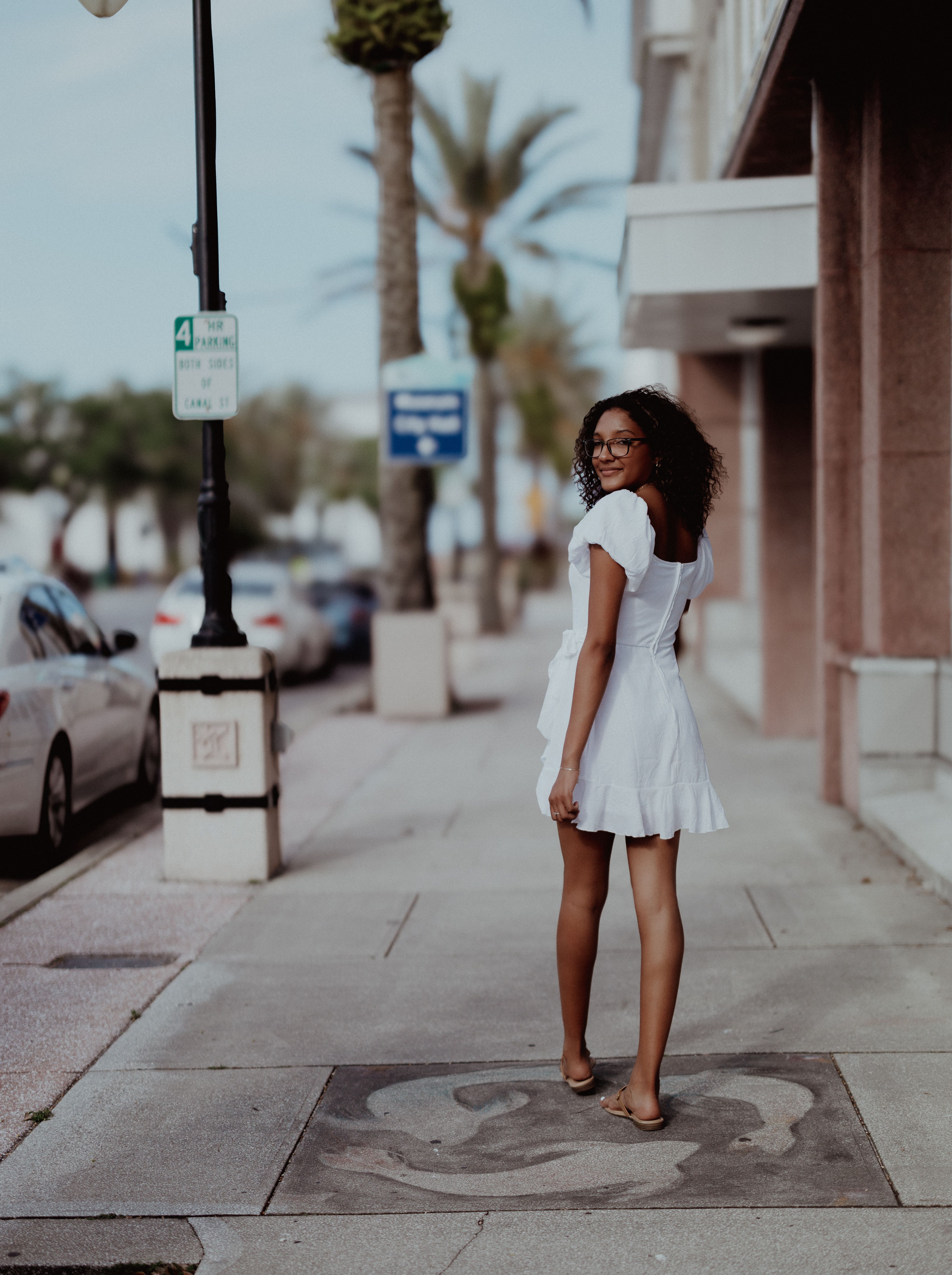 Back View of a Woman Standing on a Sidewalk · Free Stock Photo