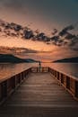 Wooden pier against mountains and sunset sky