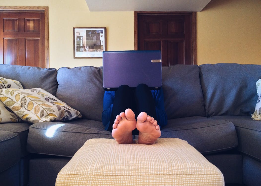 Free Person Sitting on Couch While Using Laptop Computer Stock Photo