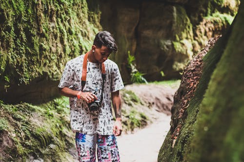 Person Holding a Camera Near Rock Formation