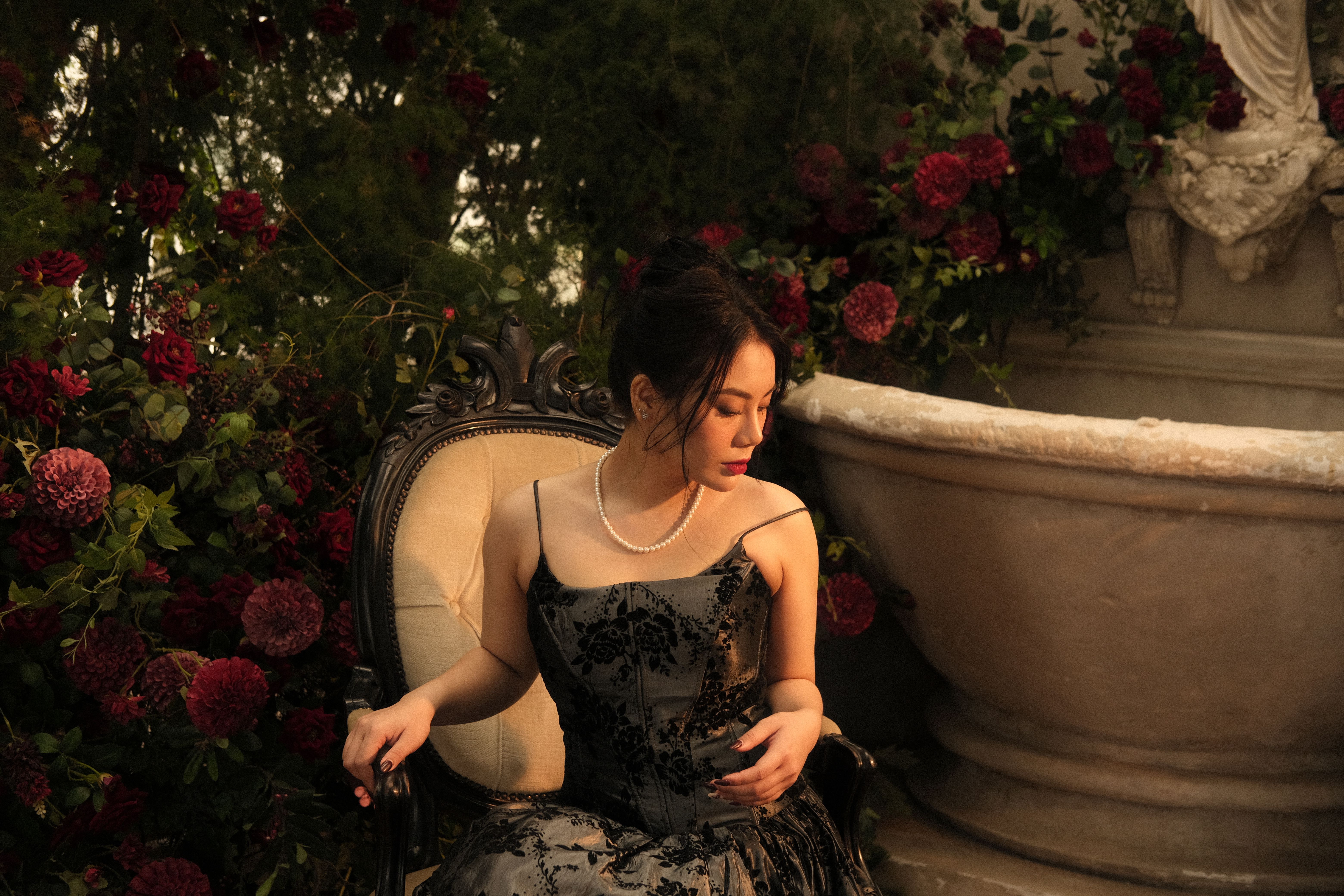 Woman in Black Dress Sitting on Chair by Fountain · Free Stock Photo