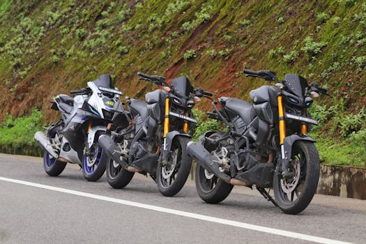 Three motorbikes parked along a scenic rural road in Munnar, India, showcasing modern bike design.