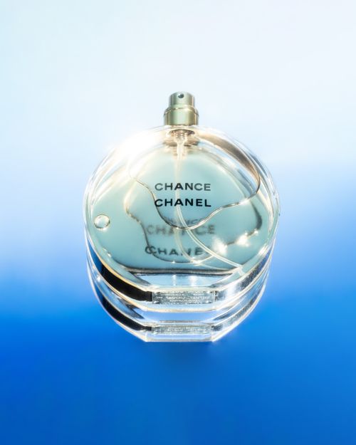 Free Elegant close-up of Chanel Chance perfume bottle against blue gradient backdrop, ideal for luxury branding. Stock Photo