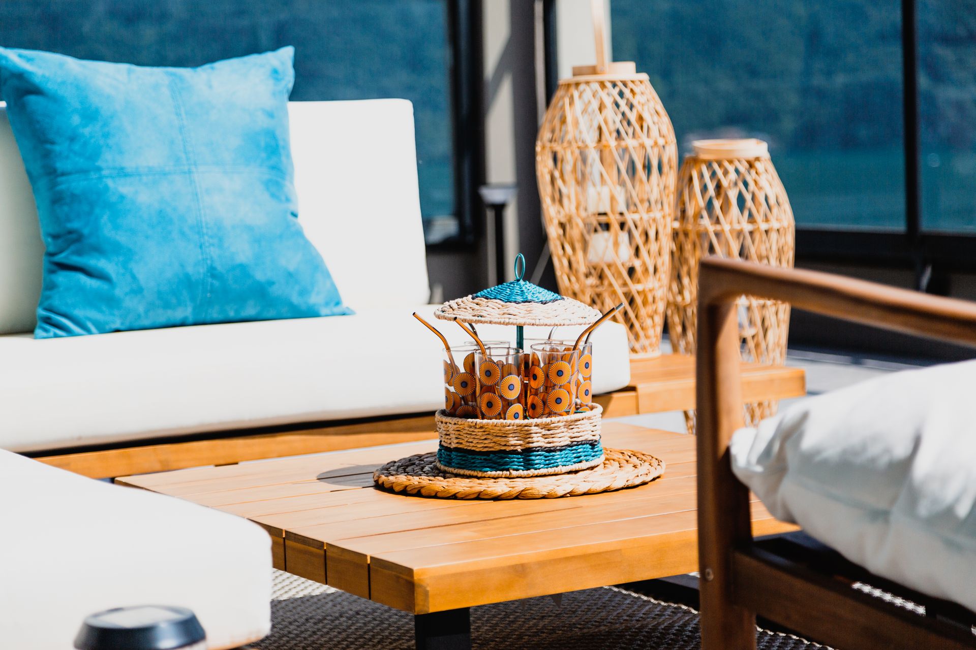 Stylish outdoor patio setup featuring wooden furniture and decorative elements, perfect for summer relaxation.