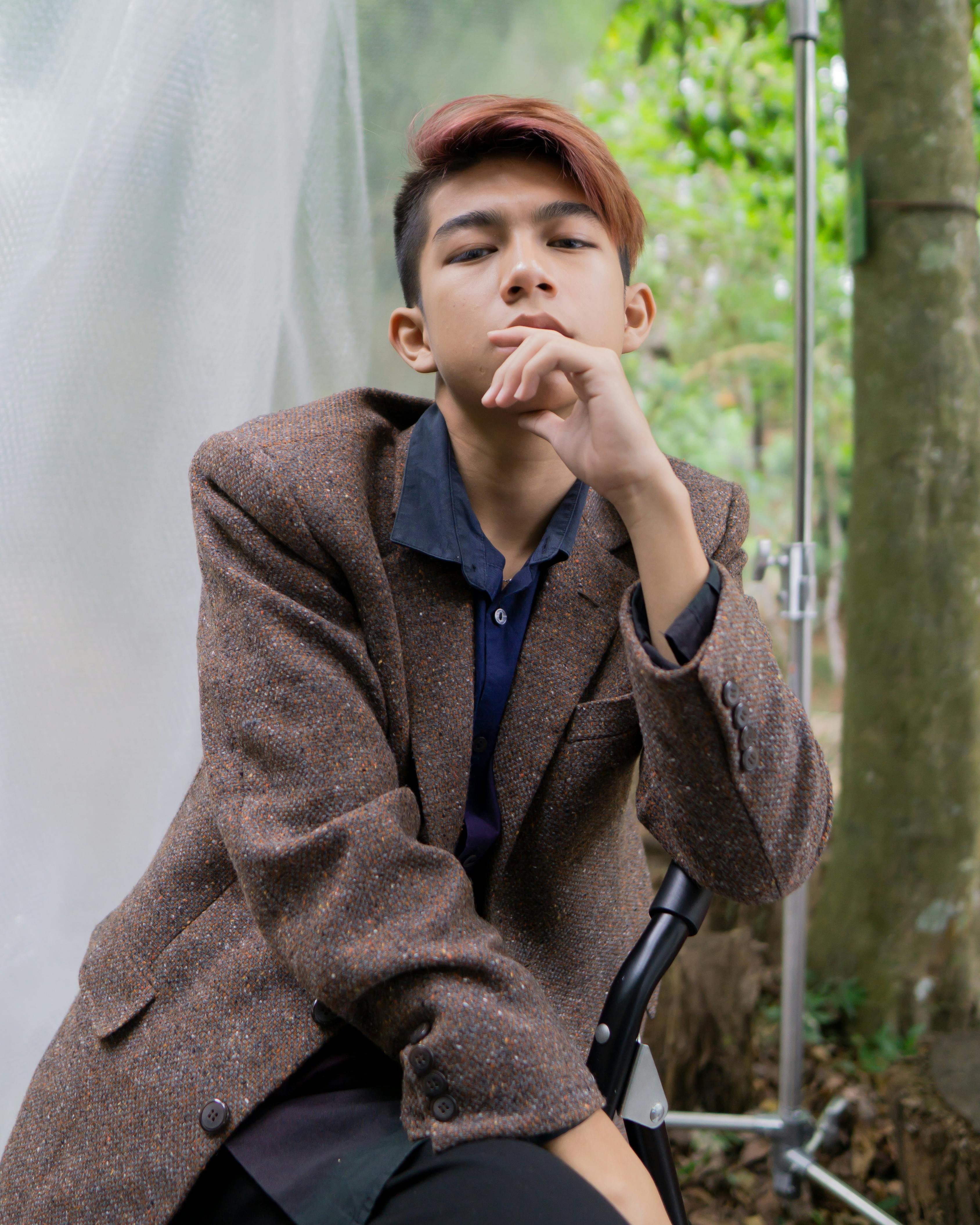 一个时尚的年轻人在户外休闲地摆出体贴的姿势