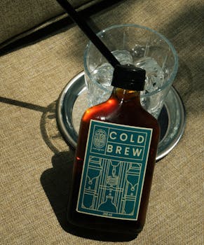 Refreshing cold brew coffee bottle with glass of ice, perfect for a hot day.