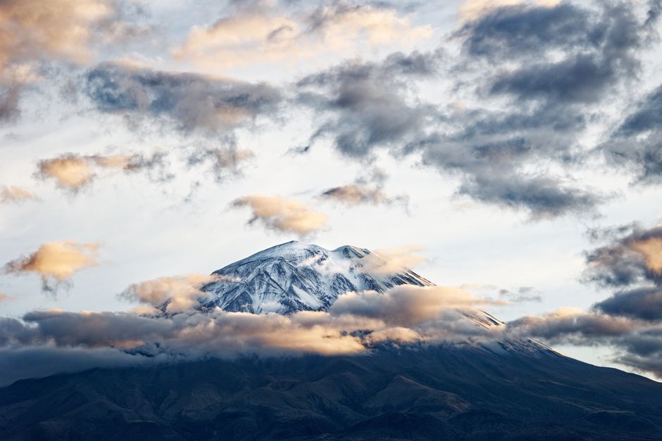 Stunning view of snow-capped Misti Volcano surrounded by clouds in Arequipa, Peru.