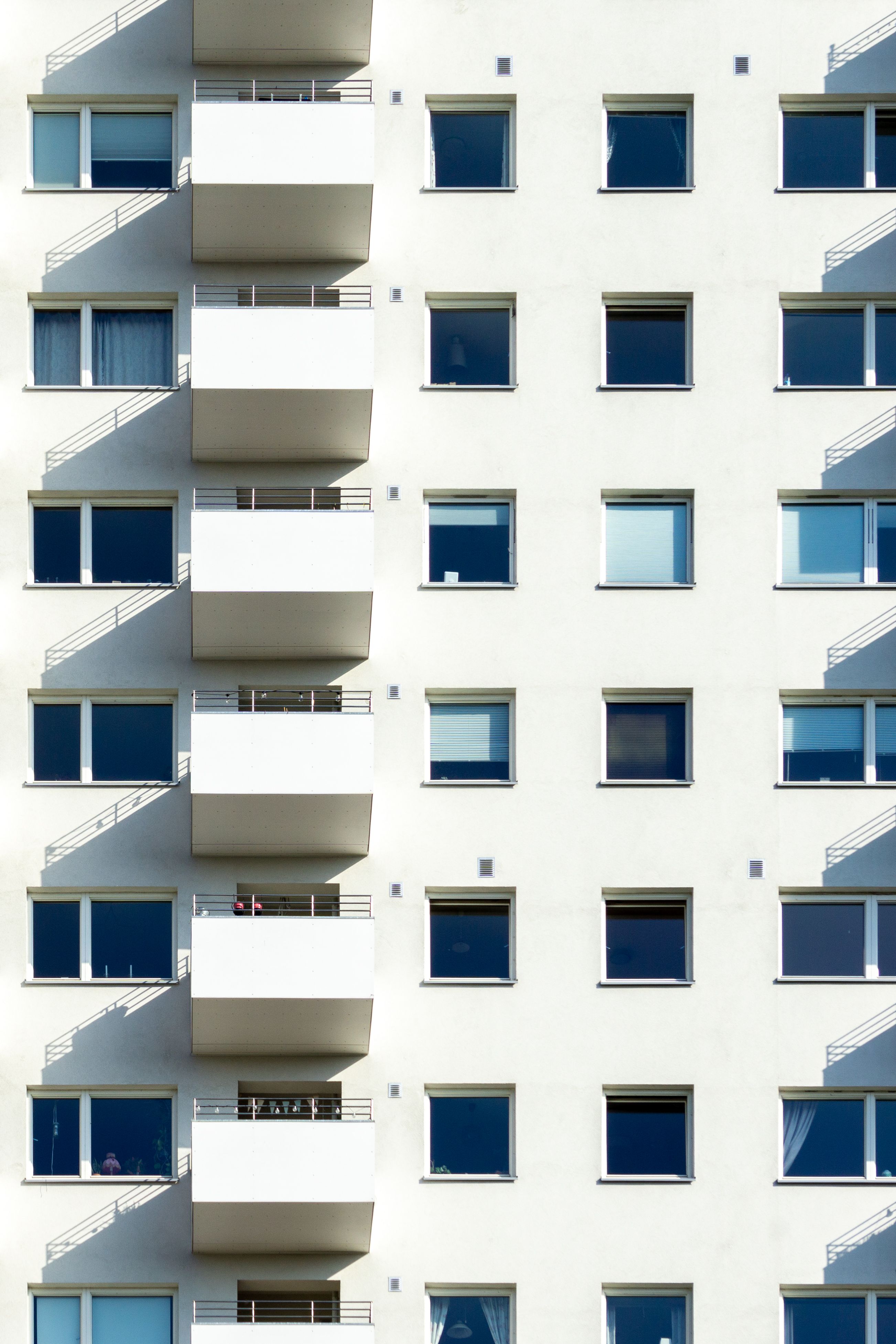Contemporary white apartment facade with balconies and windows in Oslo.