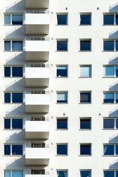 Contemporary white apartment facade with balconies and windows in Oslo.