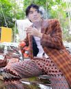一位穿着充满活力的时尚男人在户外拿着旧电话吸烟