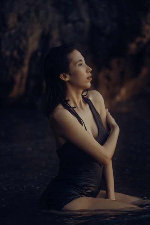 Free Artistic portrait of a woman in a swimsuit by the beach, exuding elegance and tranquility. Stock Photo