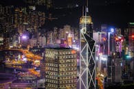 香港的摩天大楼在夜间灯火通明，展现出城市现代建筑与生活的壮观景象