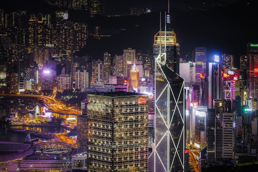 香港的摩天大楼在夜间灯火通明，展现出城市现代建筑与生活的壮观景象