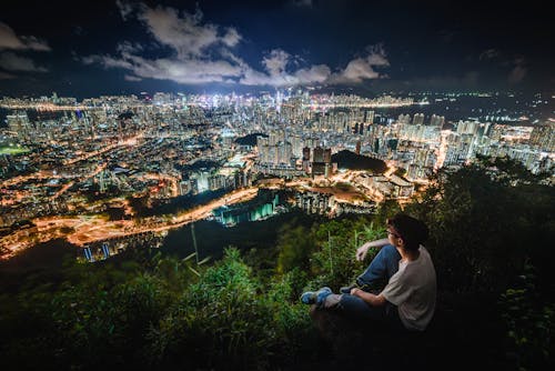 Free Photo of Man Sitting While Overlooking a City Stock Photo