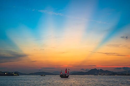 Brown And Red Junk Sailing Di Pelabuhan Saat Matahari Terbenam