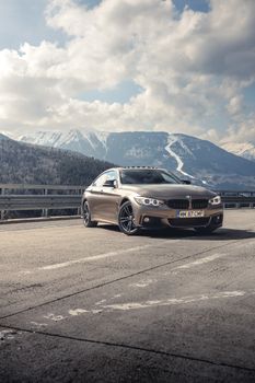 Stylish silver BMW cruising on a scenic mountain road in Romania.