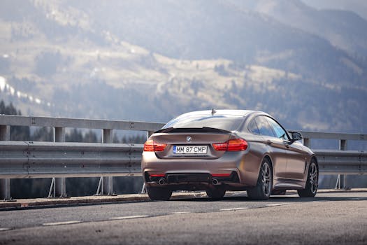 A sleek silver sports car parked on a scenic mountain road in Romania, showcasing outdoor adventure and travel.