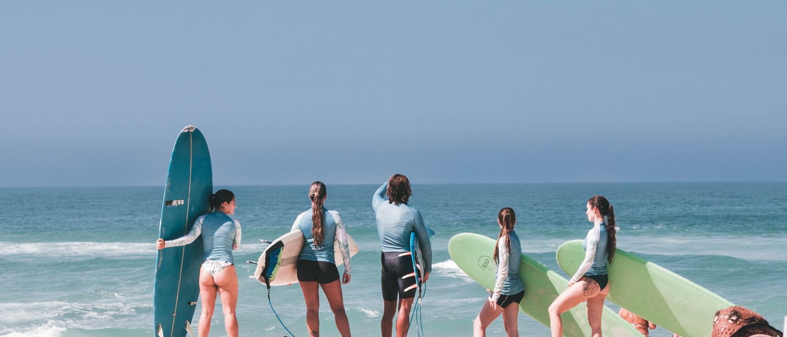 A group of surfers getting ready on a sunny beach in Rio de Janeiro, Brasil.