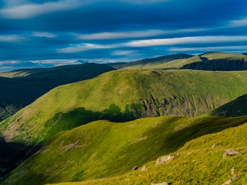 Free Vibrant green hills under a dramatic sky create a stunning landscape view, perfect for nature enthusiasts. Stock Photo