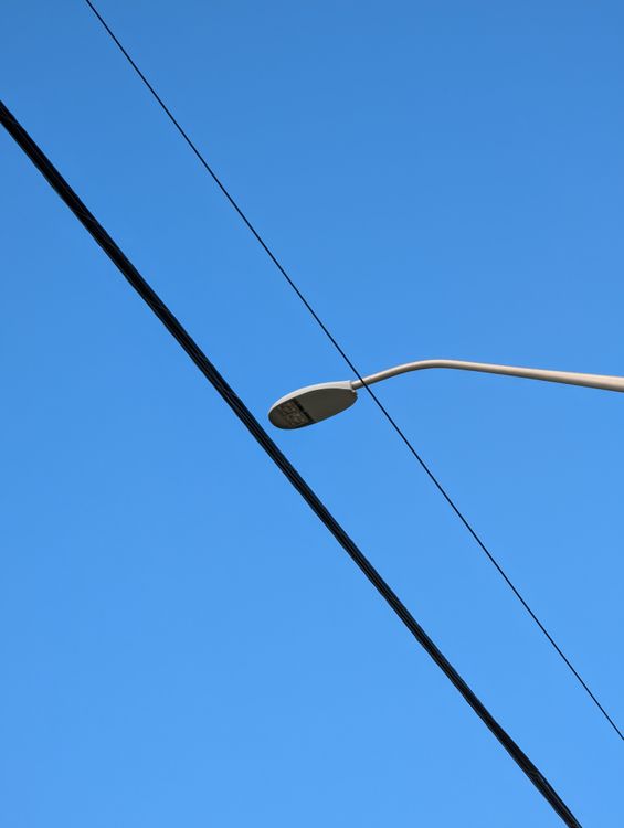 Low Angle Shot of Electricity Lines and a Streetlight under a Blue Sky ...