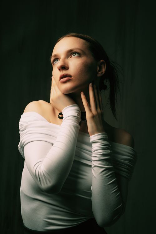 Free Moody portrait of a woman in a white blouse with hands on her neck in fashion style. Stock Photo