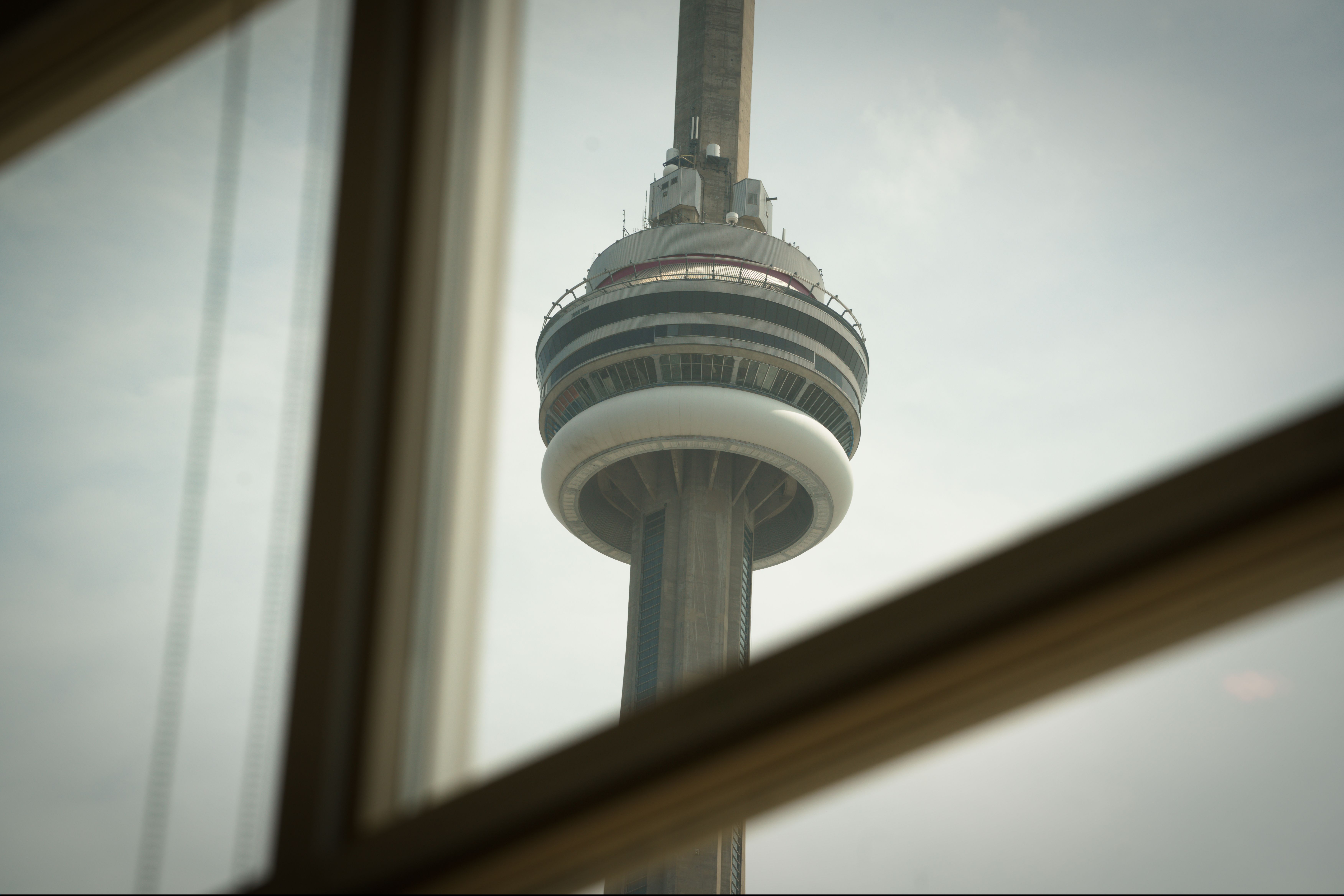 A close-up view of the CN Tower seen through a window in Toronto, Canada.