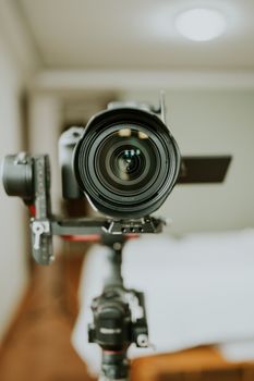 Professional camera lens on tripod in focus, showcasing photography equipment in detail.