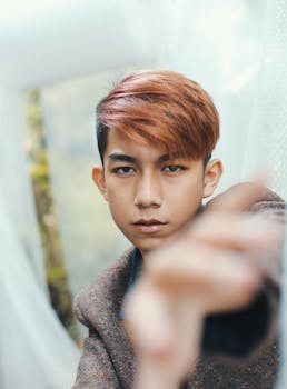 一个红头发、表情严肃的时髦年轻人，在户外