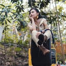 时尚女性在自然环境中摆拍，展现时尚风格