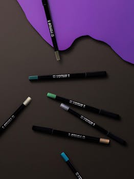 充满活力的眼线笔以紫色点缀，在深邃的暗色背景上时尚地排列，是美容与时尚编辑的完美选择