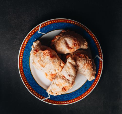 Free Delicious Argentine empanadas served on a vibrant plate, suitable for food photography. Stock Photo