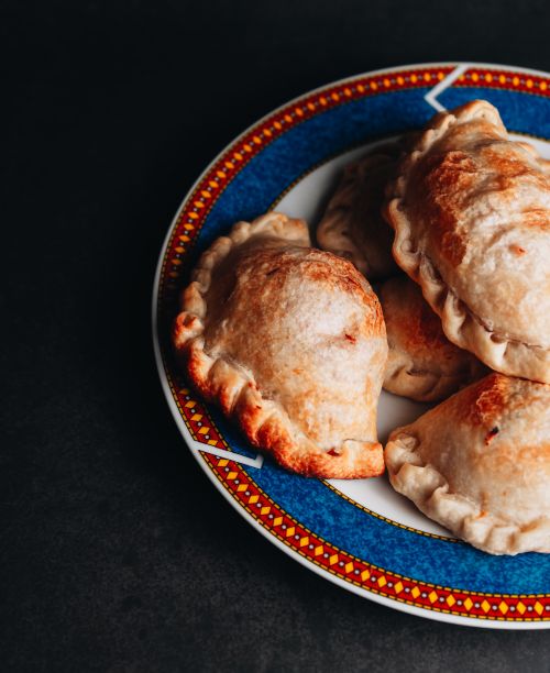 Free Delicious Argentine empanadas served on a decorative plate, perfect for a tasty meal. Stock Photo