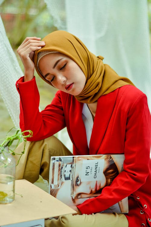 Free Woman Wearing Brown Hijab Holding Magazine Stock Photo