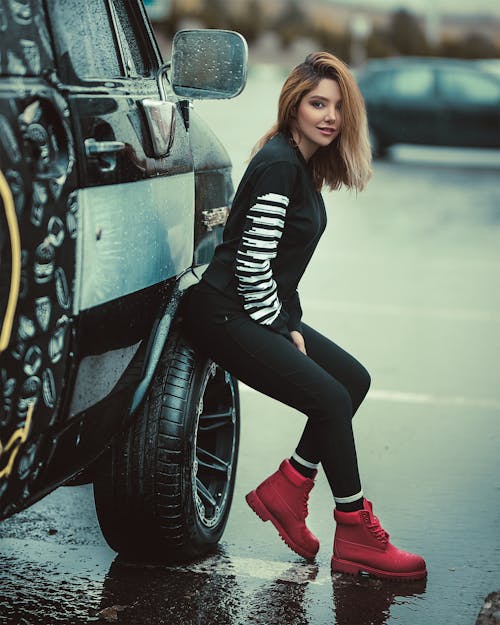 Free Woman Sitting on Parked Vehicle Front Tire Stock Photo