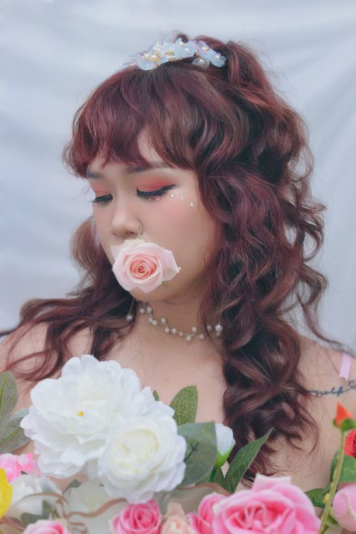 Free A delicate portrait of a woman with roses and artistic makeup, embodying elegance. Stock Photo
