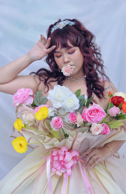 Free A woman gracefully poses with a vibrant and elegant bouquet, symbolizing beauty and celebration. Stock Photo