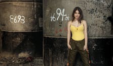 时尚女性在城市环境的涂鸦墙前自信地摆姿势