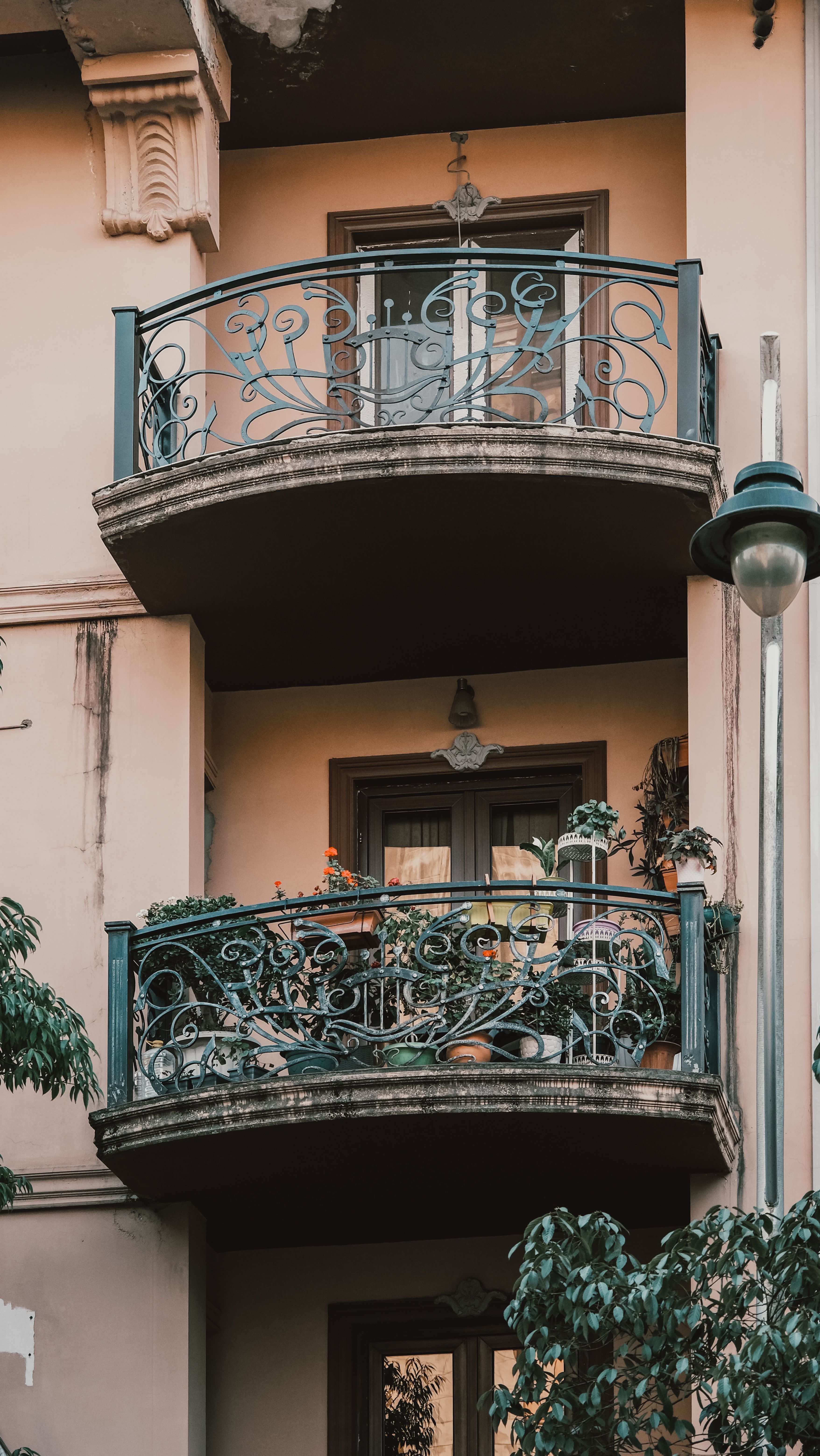 Balcoane cu balustrade din fier forjat cu modele fine, pe fațada unei clădiri de apartamente